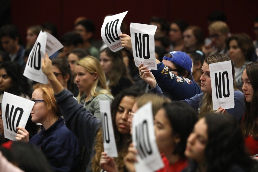UT students raise signs signifying their opposition to university leadership during a town hall event on sexual misconduct policies in January.