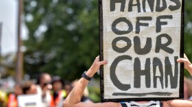 A protester outside U.S. Immigration and Customs Enforcement’s field office in Warwick, Rhode Island, on July 22, 2026. Demonstrators had hoped to keep ICE agents from detaining a Cambodian man who has lived in the state since he was an infant. Credit: Christopher Shea/Rhode Island Current