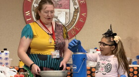 Julie Belanger, professor of chemistry at King's College, guides Rosely Espinoza , 7, of Wilkes-Barre, through a liquid nitrogen demonstration, in which a flower became brittle.
