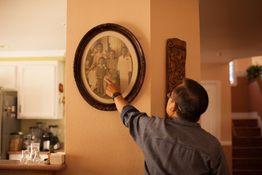 Manolo Guerra points himself out in an old family portrait. He's standing in the photo with his father, Vicente Guerra, his mother, Isabel Guerra, and his older brother Greg.