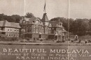 An archival publicity photo showing a large, multi-story Victorian-style hotel building with text at the bottom that reads 'BEAUTIFUL MUDLAVIA, The Home of Health in Peaceful Valley, KRAMER, INDIANA.'