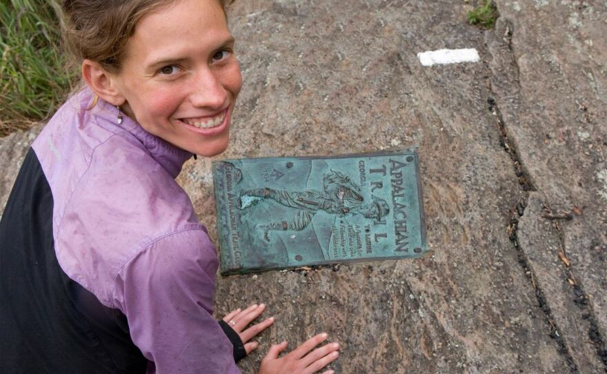 photo of Jennifer Pharr Davis on a big rock with a plaque