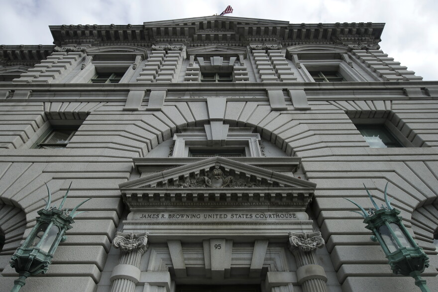 A gray building with bronze light posts flanking either side of the entrance.