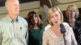 Rep. Sara Wijcicki, at microphone, sponsored legislation to make Springfield the default site for new or vacant state jobs. Gov. Bruce Rauner, left, signed the legislation Thursday, August 9, 2018.