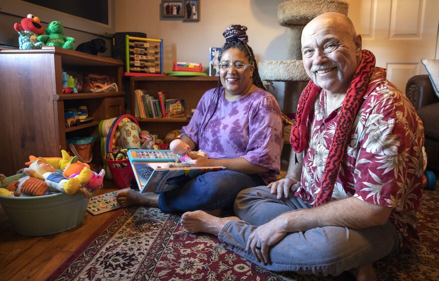 Felicia and Rick LeClair in their home, surrounded by books and toys. (Robin Lubbock/WBUR)