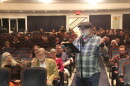 A man speaks into a microphone at a public hearing. 