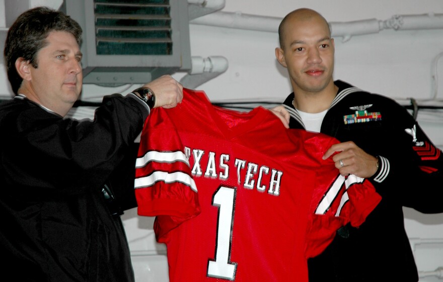  Texas Tech Head Coach Mike Leach presents Air Traffic Controller 1st Class Mitchel Deshotel a team jersey and making him an honorary team captain in 2004. Leach died Tuesday from a heart condition at the age of 61.