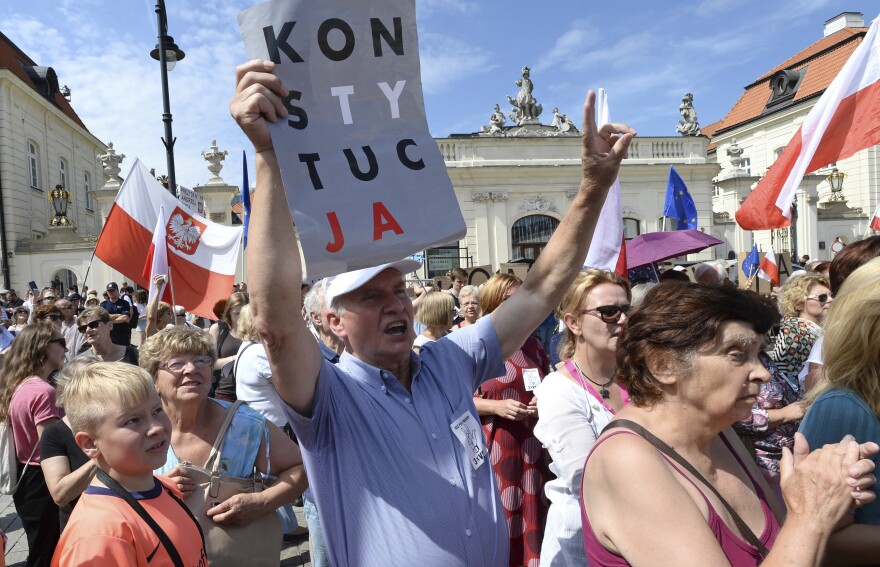 A man holds a sign that says "Constitution" at a demonstration Monday in front of the presidential palace in Warsaw, Poland.