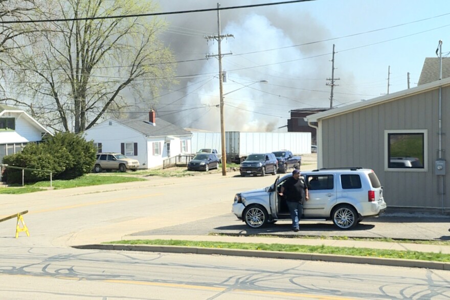 Grey and white smoke billows out of the two warehouses that caught fire. Firefighters have contained the fire, but it was still burning as of Wednesday afternoon.