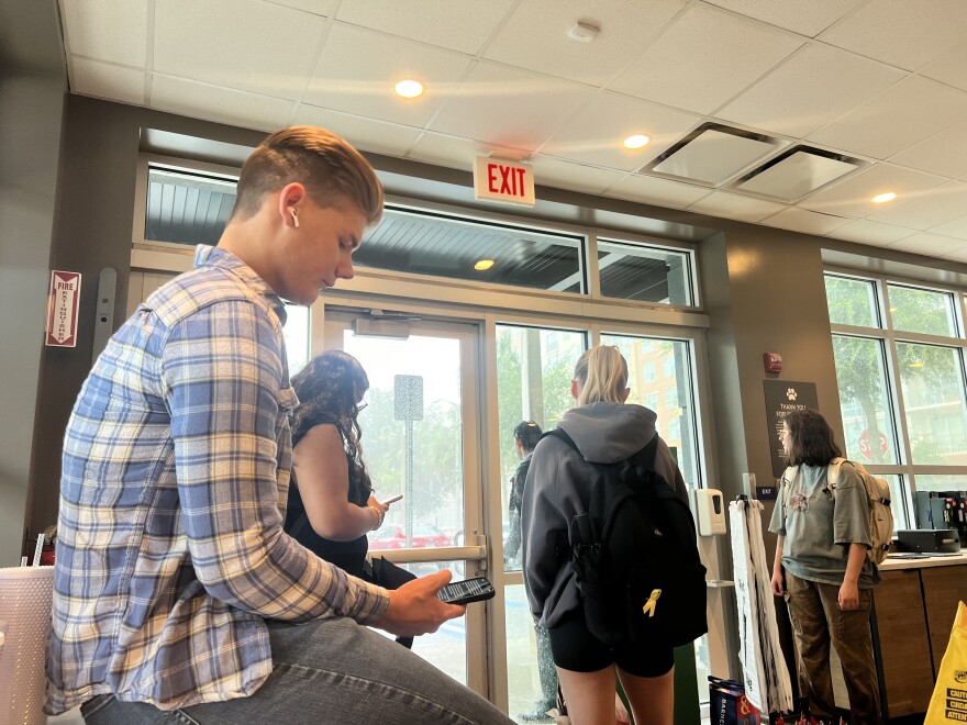 Students wait for the first bands of heavy rain from Hurricane Helene to die down before trying to leave the Publix on 13th Street near the UF campus. (Delia Rose Sauer/WUFT News)