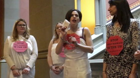 In this image taken from video, Fraidy Reiss, center, founder and executive director of Unchained at Last, a non-profit organization with the goal to end child marriages, demonstrates in chains at the State Capitol in Albany, N.Y., Tuesday, Feb. 14, 2017. (Anna Gronewold/AP)