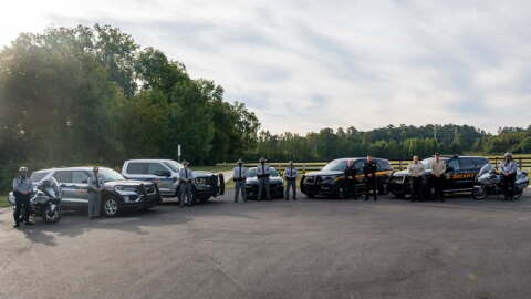 South Carolina police officers stand in front of patrol cars.