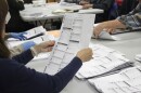 An election worker examines a ballot at the Clackamas County Elections office May 19, 2022, Oregon City, Ore.