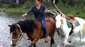 Author Alexandra Fuller on horseback crossing a river.