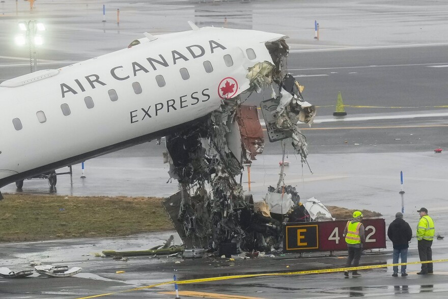 Officials investigate the site, Monday, March 23, 2026, where an Air Canada jet came to rest after colliding with a Port Authority firetruck at LaGuardia Airport, shortly after landing Sunday night in New York. (AP Photo/Seth Wenig)