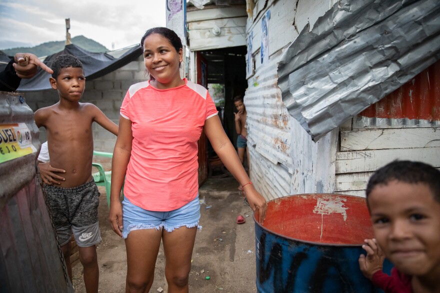 In La Paz, a low-income neighborhood on the outskirts of Santa Marta, Colombia, water service from the local utility can be erratic or nonexistent. Pictured: Neighborhood kids stand next to a rain barrel positioned under a corrugated roof.