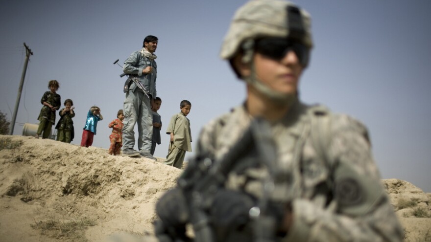 Children and an Afghan policeman look at a U.S. soldier patrolling the outskirts of Kandahar. President Obama's review of U.S. policy in Afghanistan will be unveiled soon. Although the administration is formulating an exit strategy, Afghans and other observers say it would be a  mistake for the U.S. to leave the country in its current state.