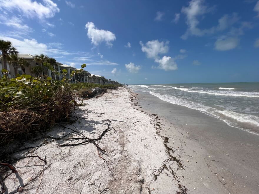 An eroded beach with homes on the left