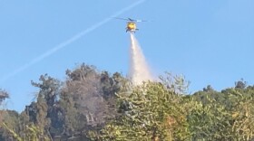 A helicopter makes a water drop on a fire near Santa Paula last year.