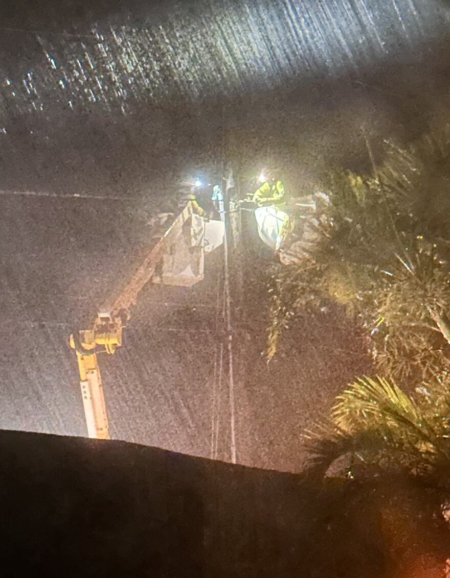 Hawaiian Electric crews work on power lines in heavy rainfall on Saturday on Molokaʻi.