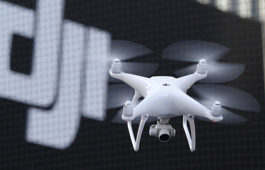 FILE - A Phantom 4, developed by major Chinese consumer-drone maker DJI, flies during its demonstration flight in Tokyo, Thursday, March 3, 2016. (AP Photo/Shizuo Kambayashi)