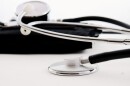 A close-up image of a shiny stethoscope sitting on a table.
