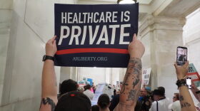 A supporter of the Arkansas Abortion Amendment holds up a sign in an Arkansas Capitol hallway while petitions to put the amendment on the November ballot are delivered in boxes to the Secretary of State on Friday, July 5, 2024.
