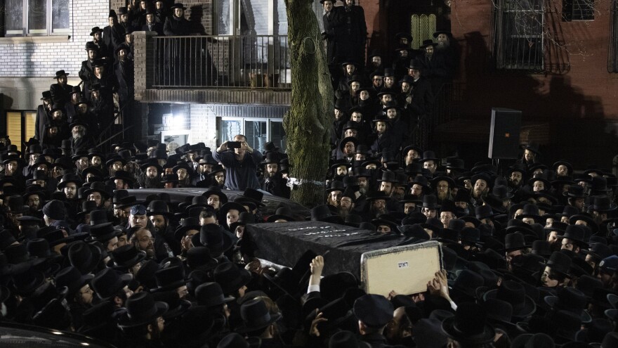 Orthodox Jewish men carry the casket of Jersey City victim Moshe Deutsch outside a Brooklyn synagogue following his funeral Wednesday in the Williamsburg neighborhood of Brooklyn.