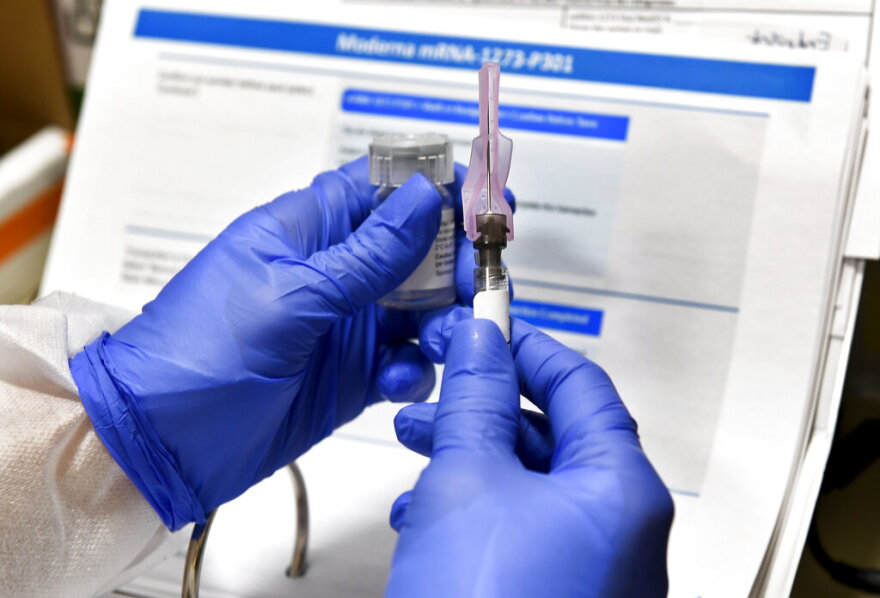 Nurse Kathe Olmstead prepares a shot that is part of a possible COVID-19 vaccine, developed by the National Institutes of Health and Moderna Inc., in Binghamton, N.Y.