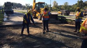 DOT workers fill the washed out bridge approach on Bluff Road at I-77.