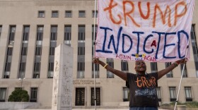 Nadine Seiler protest as she holds a banner outside federal court Tuesday, Aug. 1, 2023 in Washington. Former President Donald Trump has been charged by the Justice Department for his efforts to overturn the results of the 2020 presidential election. (AP Photo/Jose Luis Magana)