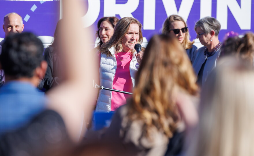 Democratic nominee for lieutenant governor Winnie Brinks speaks in East Lansing, Mich., on Oct. 22, 2026, during the first stop on gubernatorial nominee Jocelyn Benson's statewide "Driving Down Costs" bus tour.