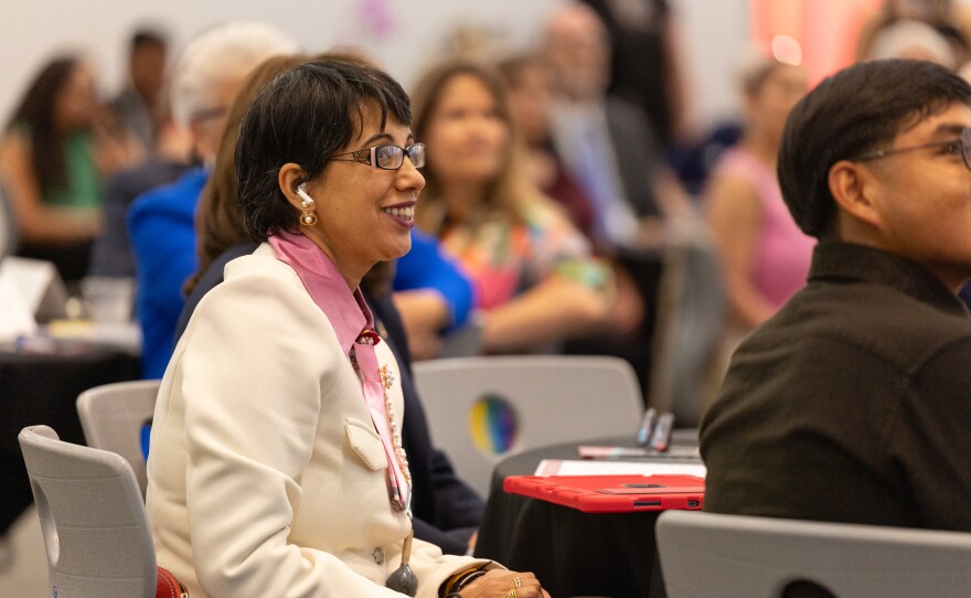 Dr. Dhawan looks on with a smile as she listens to the praise speakers were giving her.