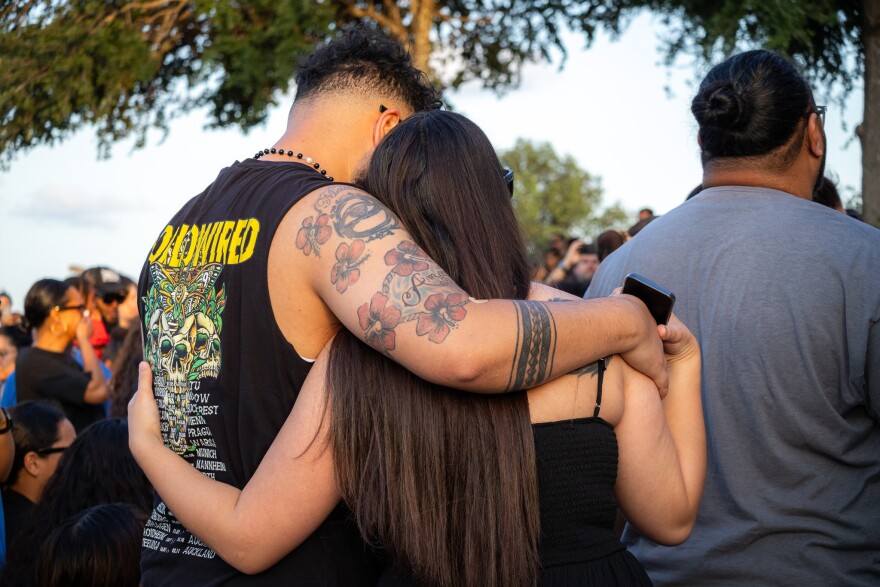 Tyron Tufono, son of victim Matthew Angel Tufono, hugging a family member.