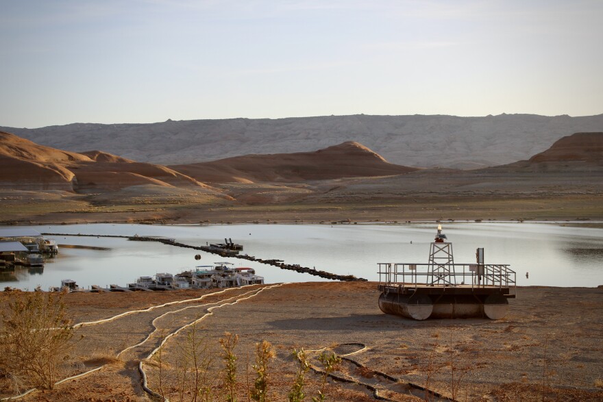 Docks and buoys that once floated atop dozens of feet of water sit stranded on the sand at Lake Powell's Bullfrog Marina on April 9, 2023. Management of the reservoir, which is filled with mountain snowmelt, is a major focus of competing proposals for how to share the Colorado River going forward.