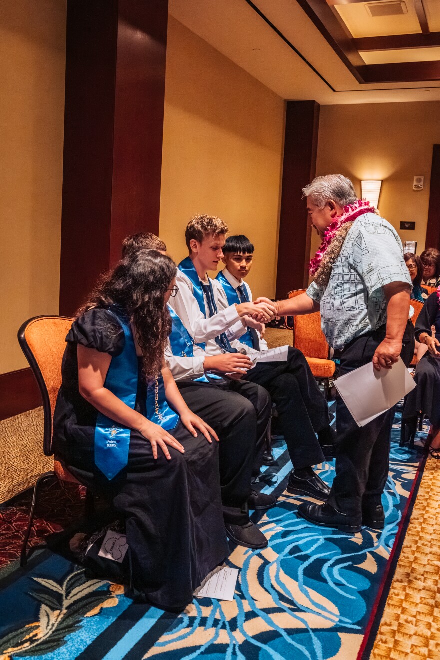 State DOE Superintendent Keith Hayashi congratulating the graduates after each delivering a speech to family members, Aulani cast and crew, and Project SEARCH staff.