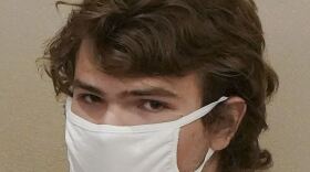 The face of Payton Gendron, wearing a white face mask.
