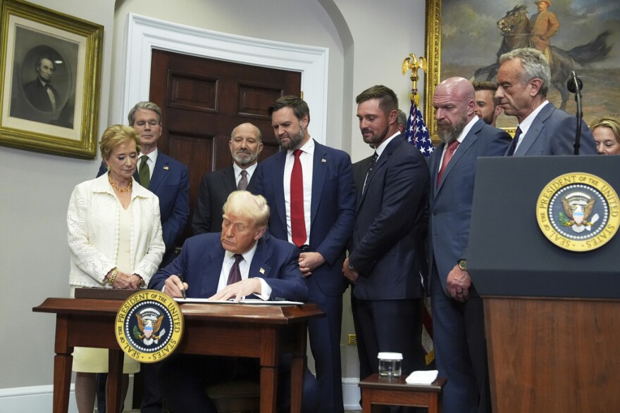 President Donald Trump signs an executive order restarting the Presidential Fitness Test in public schools as Secretary of Education Linda McMahon, from left, Treasury Secretary Scott Bessent, Commerce Secretary Howard Lutnick, Vice President JD Vance, professional golfer Bryson DeChambeau, WWE CCO Paul "Triple H" Levesque, and Health Secretary Robert F. Kennedy Jr. watch, Thursday, July 31, 2025.