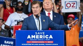 Mehmet Oz, who is running for the US Senate, speaks as former US President Donald Trump stands behind him during a campaign rally.