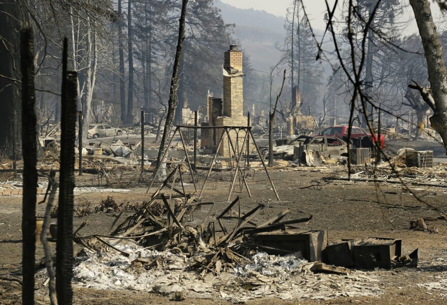 A swing set stands among the remains in a  neighborhood in Santa Rosa, Calif. (Eric Risberg/AP)
