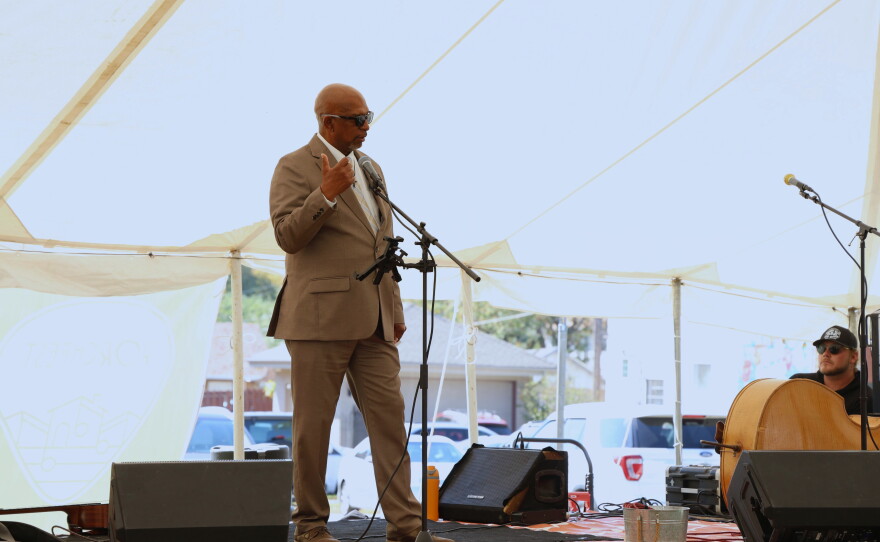 Joplin Mayor Pro Tem Keenan Cortez speaks at the opening announcements of the 10th annual North Heights Porchfest on Oct. 10, 2026. He's standing on a flat bed trailer that's been made into a stage and speaking into a microphone. 