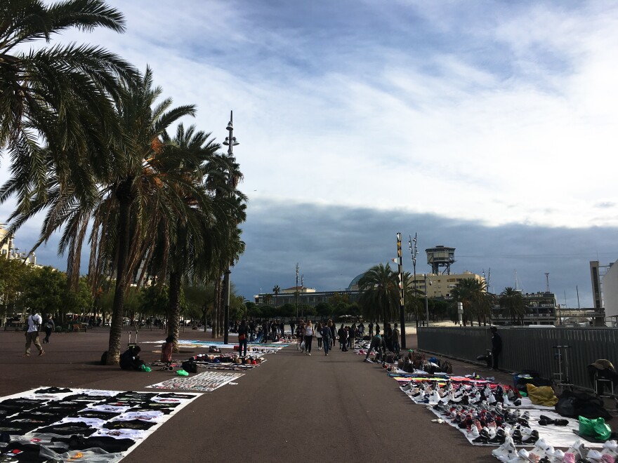 A boardwalk in Barcelona, Spain, is lined with "blanket" markets, where primarily African migrant peddlers sell low-cost merchandise.