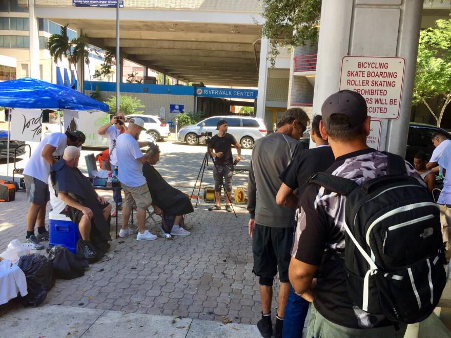 Homeless people wait in line for a free haircut.