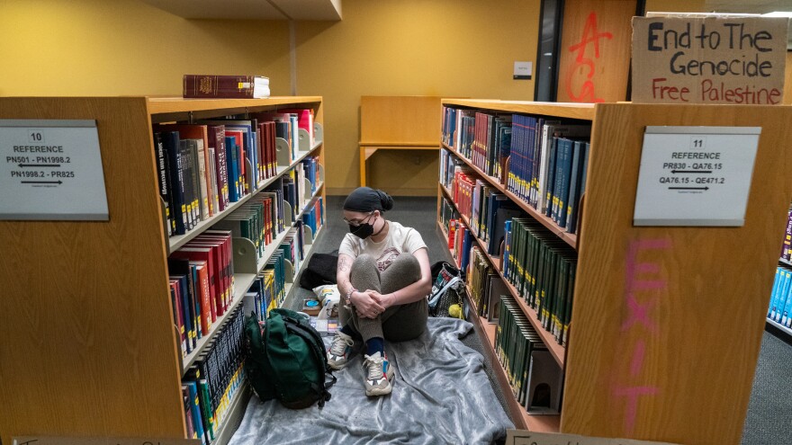 A person prepares to rest for the evening in the library, inside the occupied Branford Price Millar Library at Portland State University on April 30. All books were shelved and no books were seen damaged or disturbed.