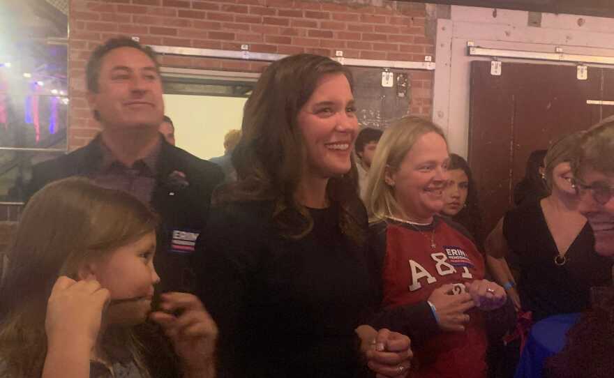 Woman smiles in crowd of supporters.