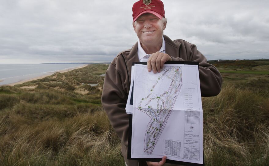 Trump holds the plans for the MacLeod Course, his second Scottish golf course, during a visit to the Trump International Golf Links, on June 6.