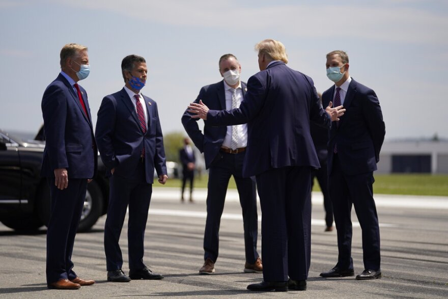 President Donald Trump, second from right, speaks with from left, Rep. Fred Keller, Rep. Dan Meuser, Rep. Brian Fitzpatrick, Rep. Scott Perry after arriving at Lehigh Valley International Airport in Allentown, Pa., Thursday, May 14, 2020. (AP Photo/Evan Vucci)