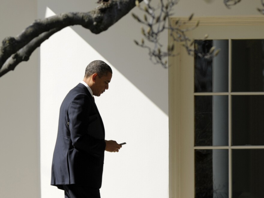 President Obama appears to check smartphone as he heads for the Oval Office after speaking to the UAW, Tuesday, Feb. 28, 2012.