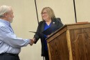 Mayor Lilija Stevens presents a proclamation to Washington resident Al Ponto that recognizes his heroic actions that alerted his neighbors to a fire at their home.
