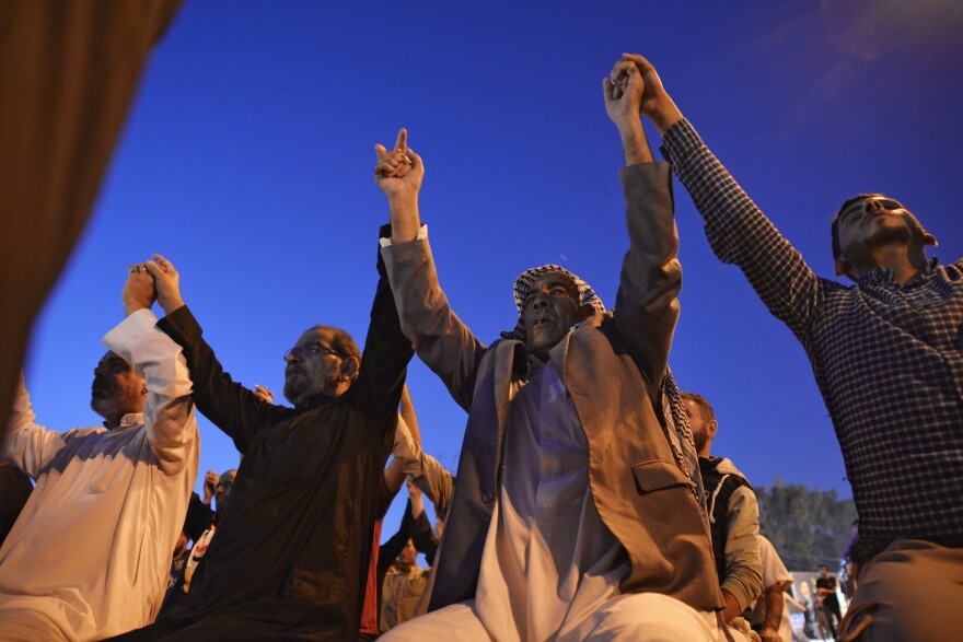 Iraqi protesters join hands after taking part in prayers during anti-government demonstrations in the Shiite holy city of Najaf, in November 2019. The anti-government protests began in October, leading to the prime minister's resignation.